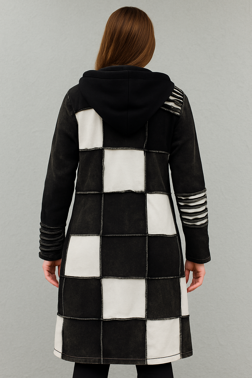 Achterzijde van lang boho vest met zwart-witte patchworkblokken en zwarte capuchon β handgemaakt in Nepal β Menikleding.nl