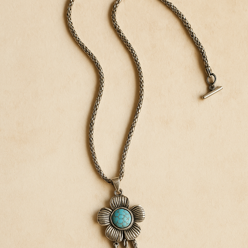 Zilverkleurige boho ketting met bloemvormige hanger en turquoise steen – handgemaakte bohemian ketting