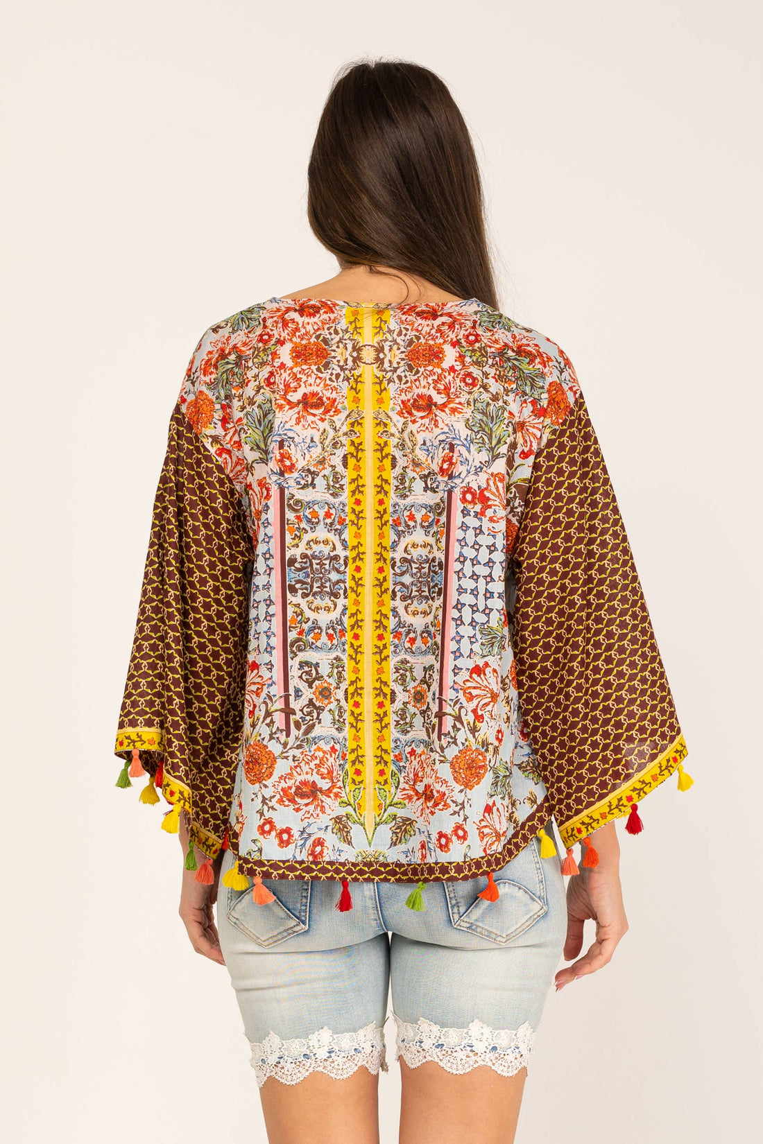 Achterkant van boho kimono blouse met bloemen- en etnische print en gele details.