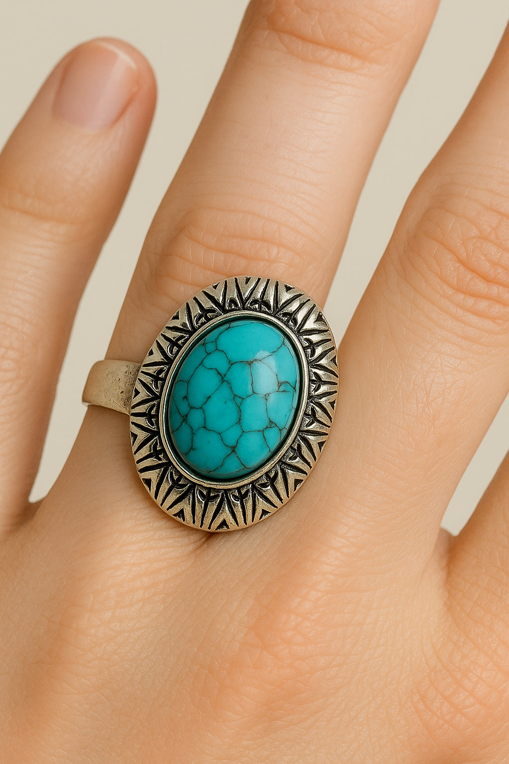 Boho ring met grote turkoois steen en zilverkleurig motief – gedragen aan de hand