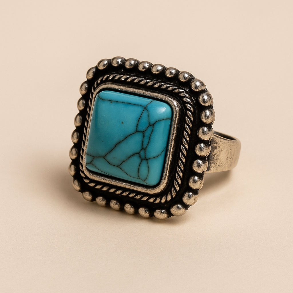 Boho ring met vierkante turkoois steen en decoratieve zilverkleurige omlijsting – productfoto Menikleding