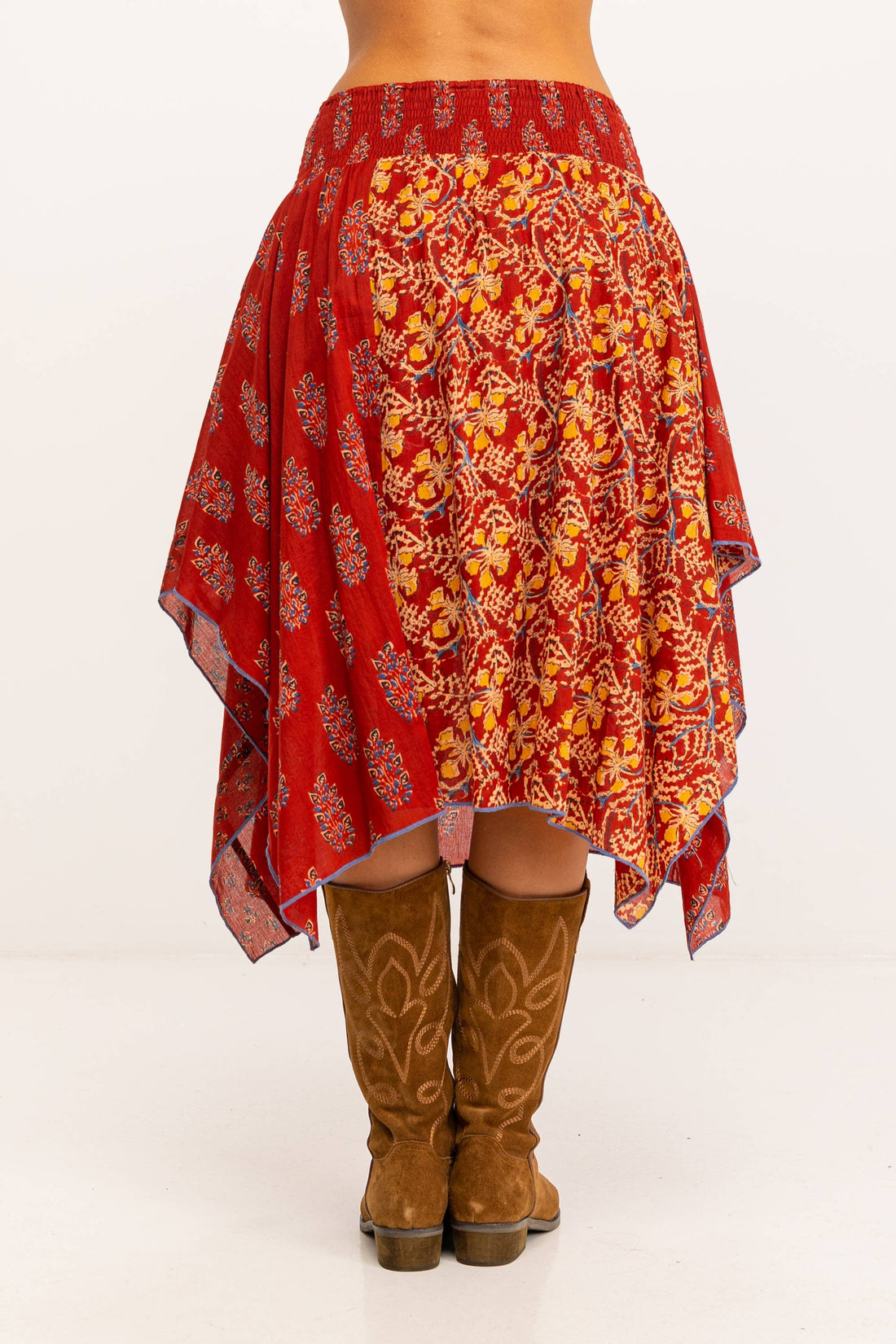 Achterkant van bohemian rok in rood met handblockprint en wijde asymmetrische vorm.