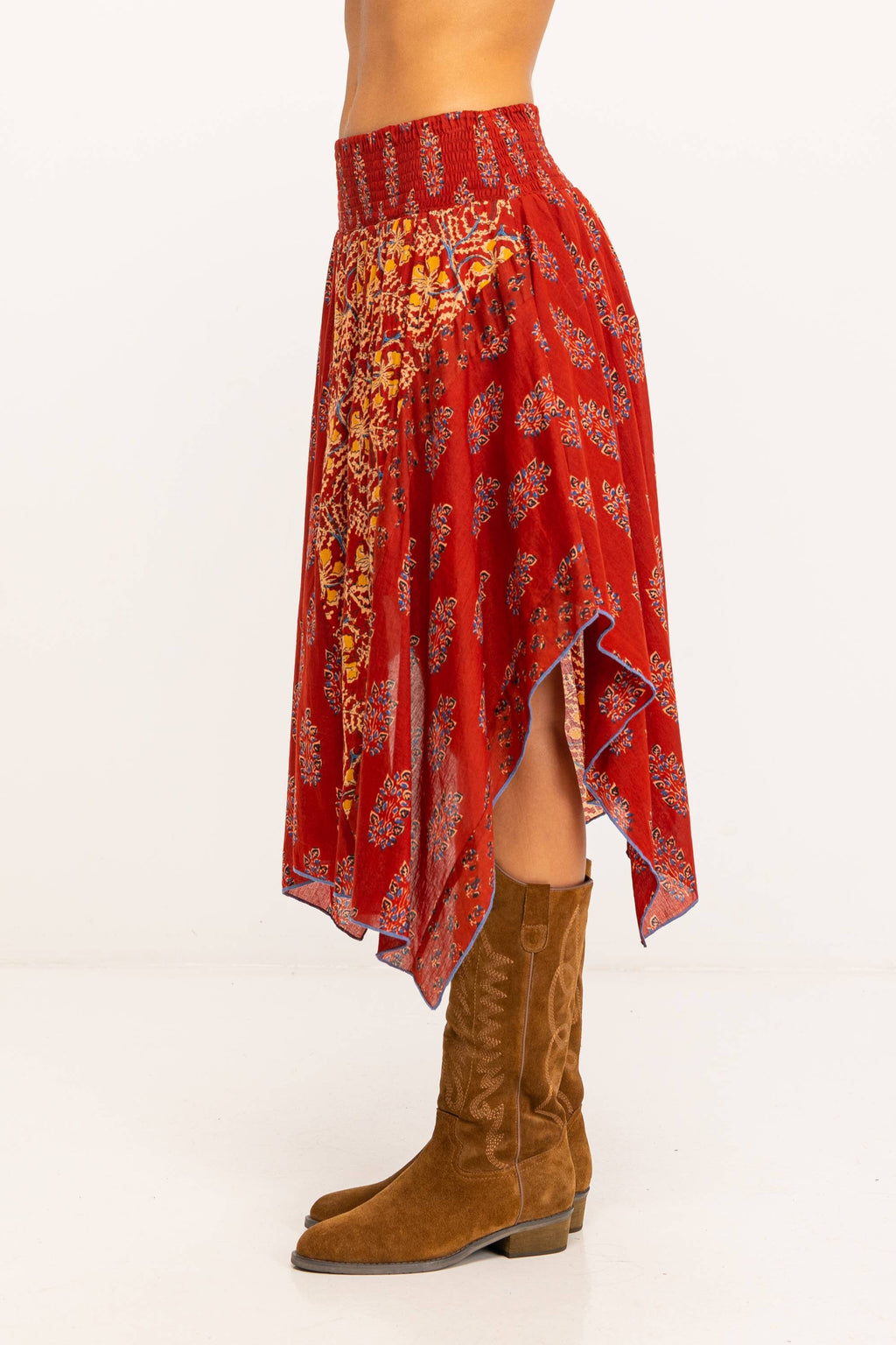 Zijaanzicht van rode boho rok met asymmetrische zoom en handgedrukte bloemenprint.