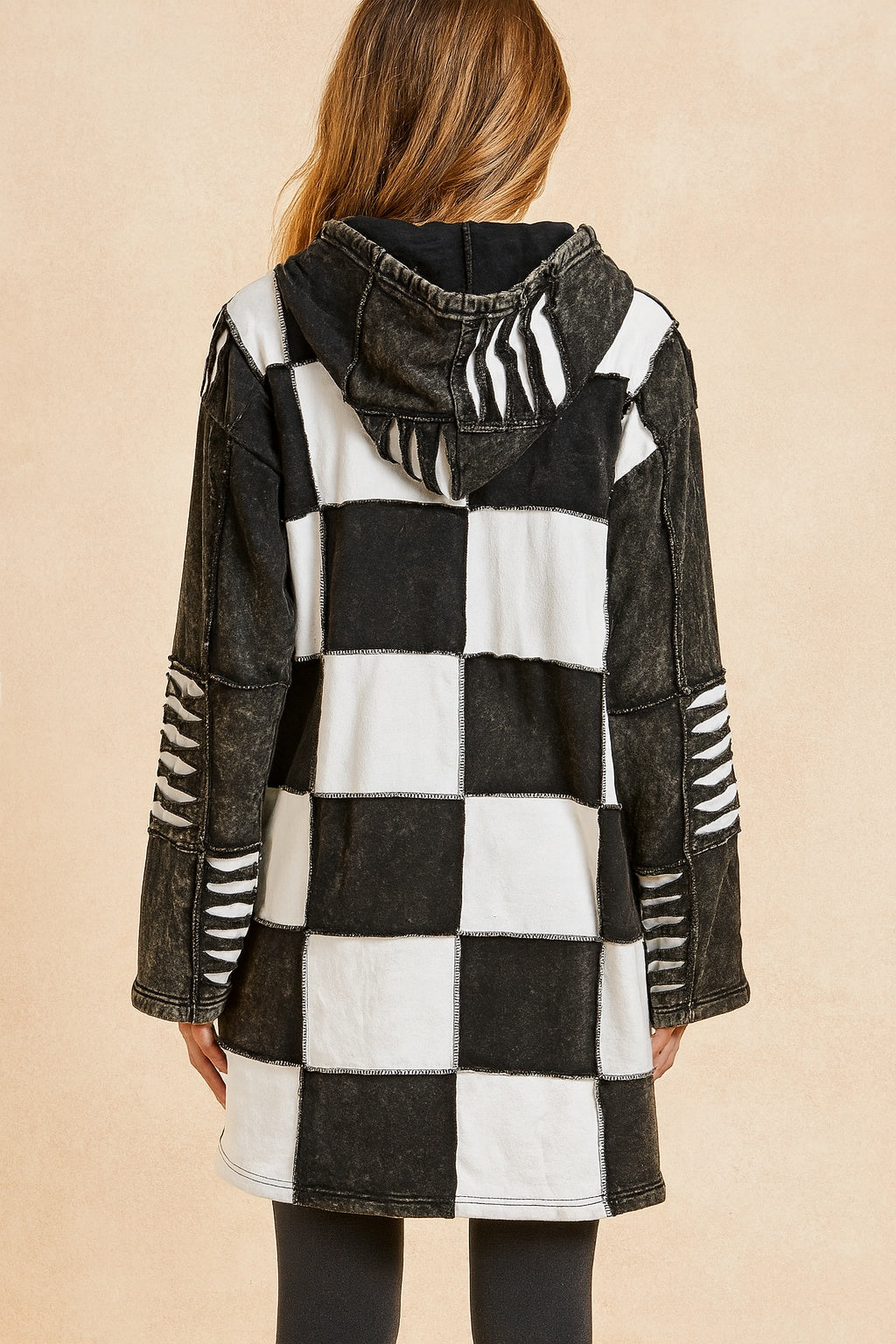 Achterkant van boho spijkerjas met capuchon en zwart-wit blokpatroon.