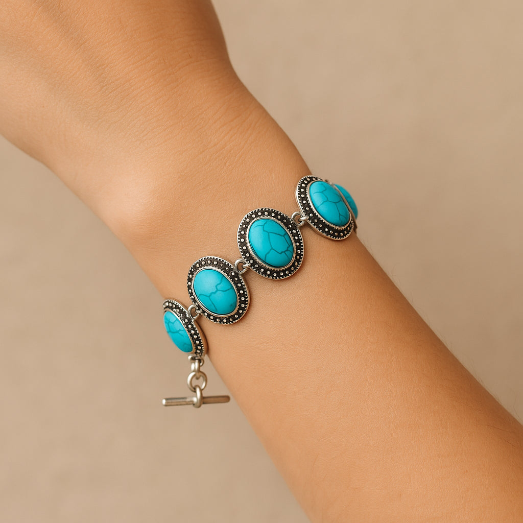 Model draagt zilverkleurige boho armband met turquoise ovale stenen – handgemaakte bohemian accessoire