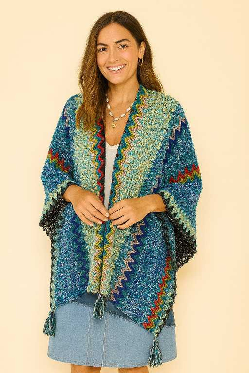 Vrouwelijk model met handgemaakte blauwe boho omslagdoek van wolmix en viscose – open vallend model met franjes – Menikleding.nl