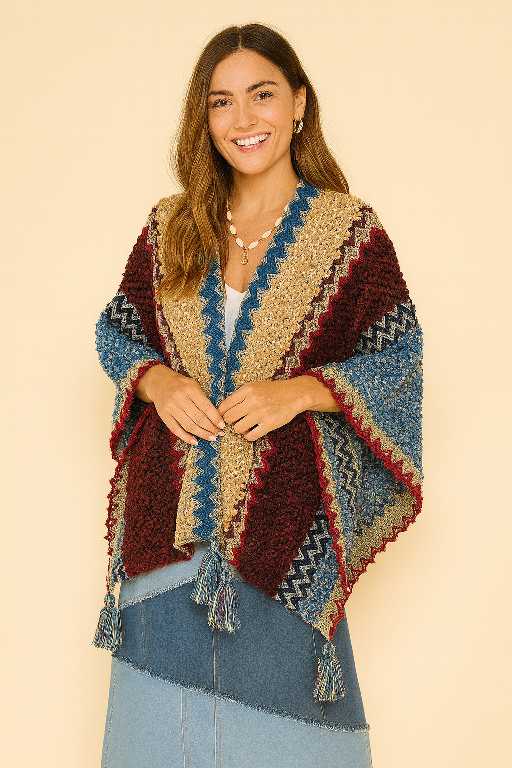 Handgemaakte boho omslagdoek in rood, blauw en beige – wolmix en viscose – vrouwelijk model draagt de doek open – Menikleding.nl