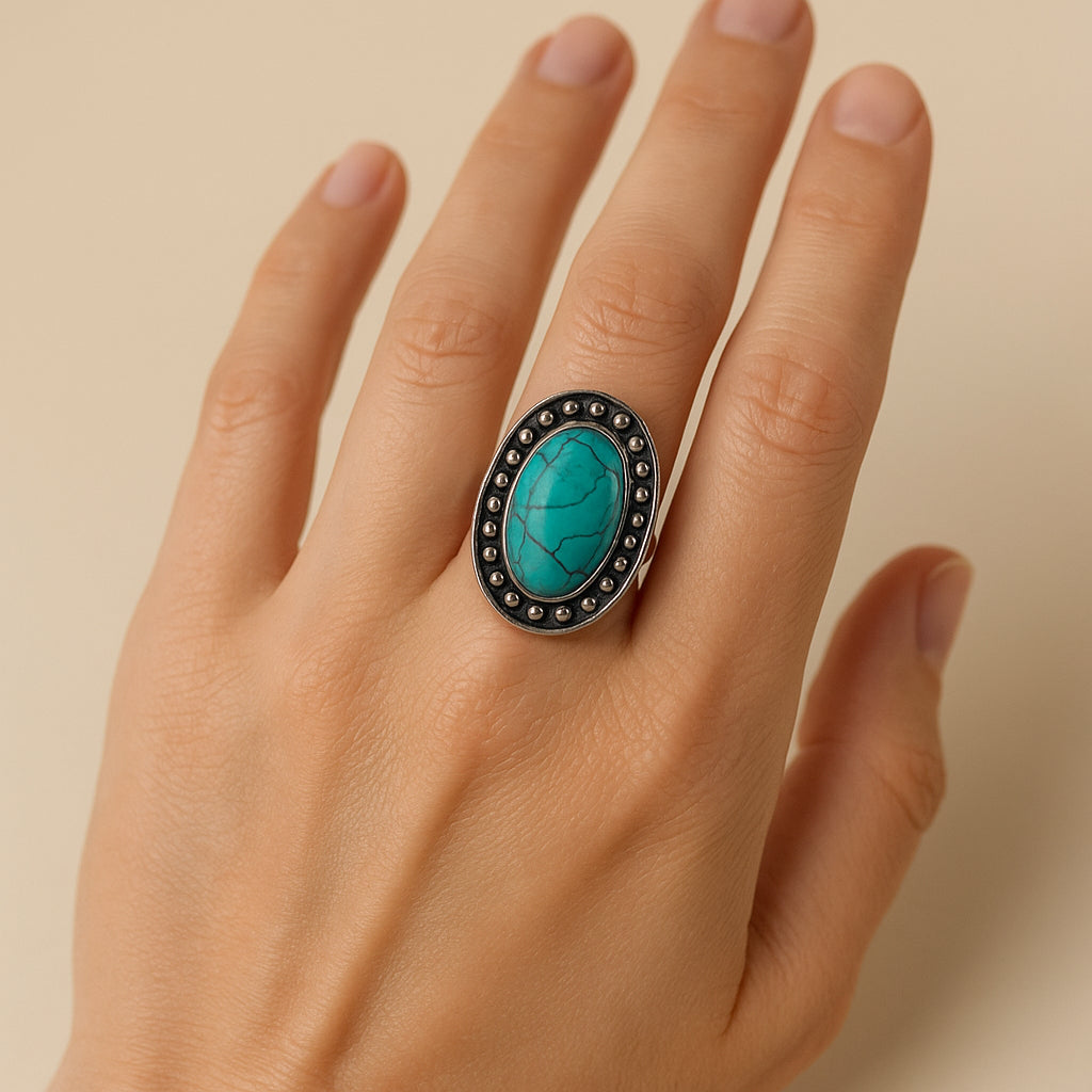 Ovale ring met turkoois steen en zilverkleurige boho details – gedragen aan de hand