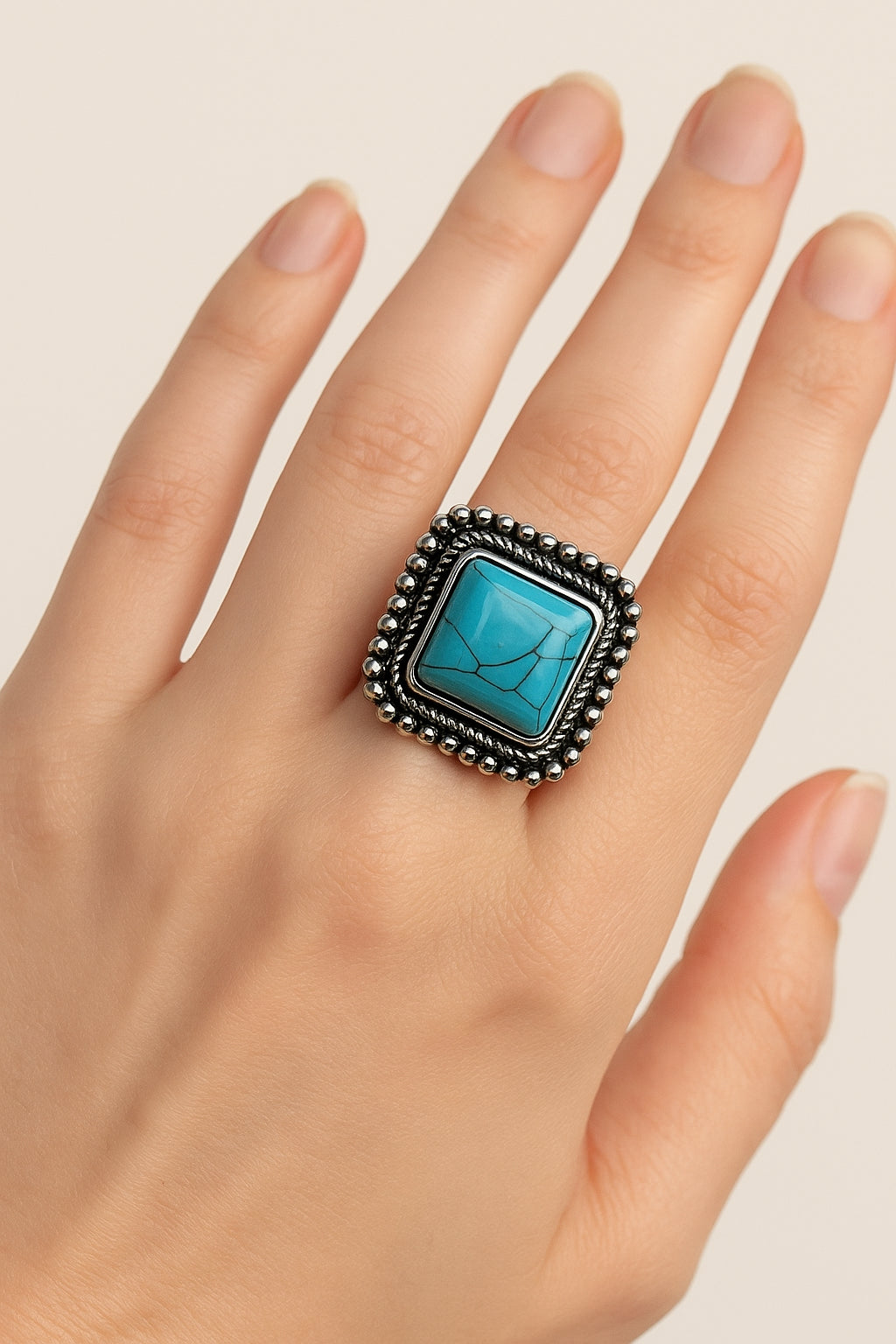 Vierkante boho ring met turkoois steen, gedragen aan de hand – zilverkleurig vintage design